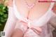 A woman in a pink lingerie and stockings posing for the camera.