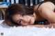 A woman laying on top of a white rug.