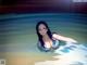 A woman in a swimming pool with glasses on.
